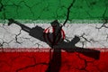 Hand assault rifle on the background of the flag of Iran and cracks. Iran Power Concept