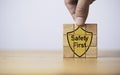 Hand assemble safety first icon on wooden block cube for worker caution work hazards in work place by zero accident concept Royalty Free Stock Photo