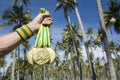 Hand of Athlete Holding Gold Medals Palm Trees