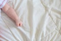Hand baby clenched into a fist on the bed. The child is sleeping. Hands of a child in a tone Royalty Free Stock Photo