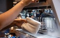 Hand of barista cleaning milk frother of coffee machine to be ready for milk frothing Royalty Free Stock Photo