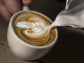 Hand on Barista making latte cafe, Cup of coffee with beautiful Latte art on white cup Royalty Free Stock Photo