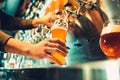 Hand of bartender pouring a large lager beer in tap. Royalty Free Stock Photo