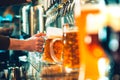 Hand of bartender pouring a large lager beer in tap. Royalty Free Stock Photo