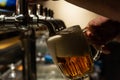 Hand of bartender pouring a large lager beer in tap. Rest in a bar with friends Royalty Free Stock Photo