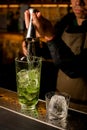 hand of the bartender pours drink from jigger into mixing cup with ice Royalty Free Stock Photo