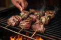 hand basting grilled lamb chops on a hot outdoor grill