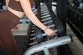 Hand of a beautiful young woman holding a dumbbell from a group of dumbbells lined up in the gym to be used. Healthy mind in a