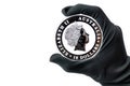 Hand in black glove holding large silver dollars coin