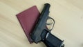 A hand in black glove putting nternational passport of the Russian Federation and gun Makarov pistol on a table as a symbol of Royalty Free Stock Photo