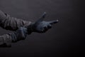 Hand in black gloves of a crime on a black background. Gloves are worn on the hand. The man puts a black glove on his Royalty Free Stock Photo