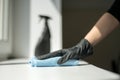 A hand in black gloves holds a microfiber cleaning cloth and a spray with sterilizing make disinfection for good hygiene Royalty Free Stock Photo