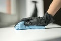 A hand in black gloves holds a microfiber cleaning cloth and a spray with sterilizing make disinfection for good hygiene Royalty Free Stock Photo