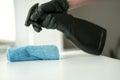 A hand in black gloves holds a microfiber cleaning cloth and a spray with sterilizing make disinfection for good hygiene Royalty Free Stock Photo