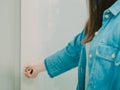 Hand of black hair woman with blue jean shirt hold on door knob Royalty Free Stock Photo