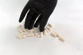 Hand in black latex glove taking pill from a bunch of drugs