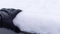 Hand in black leather glove on snow-covered railing of the bridge on white snowy background Royalty Free Stock Photo