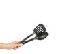 Hand with Black plastic kitchen spoon and spatula, kitchenware for cooking Royalty Free Stock Photo