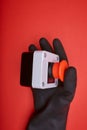 The hand in black resin glove, which pushes the emergency button at the red background Royalty Free Stock Photo