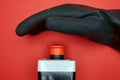 The hand in black resin glove, which is ready to push the emergency button at the red background Royalty Free Stock Photo