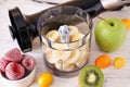 Hand blender and accessories with sliced fruit on a wooden background. Close up Royalty Free Stock Photo