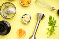 Hand blender and accessories with sliced fruit on a yellow background, closeup. Top view Royalty Free Stock Photo