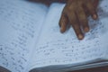 A hand of a blind person reading a braille system book