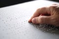 Hand of a blind person reading some braille text touching the relief