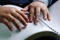 Hand of the blind reading a book Braille.