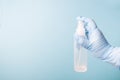 A hand in a blue disposable medical glove holds an antiseptic in the form of a spray, an alcohol solution for disinfecting surface Royalty Free Stock Photo