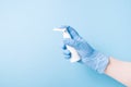 hand in blue disposable medical glove holds spray for throat and nose, treatment of colds and sore throats, colds and flu concept