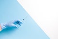 hand in blue disposable rubber glove holds an insulin syringe with injection on a blue background Royalty Free Stock Photo