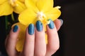 Hand with blue glitter nails with flower