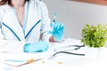 The hand in blue glove holding syringe against white medical gown Royalty Free Stock Photo