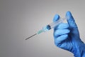 Hand in a blue glove holding a syringe Royalty Free Stock Photo