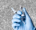 Hand in blue glove holding a vaccine vial and syringe Royalty Free Stock Photo