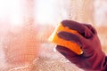 Hand blue glove washes window with yellow sponge Royalty Free Stock Photo