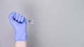 Hand in blue gloves of doctor or nurse holding syringe with liquid vaccine over Royalty Free Stock Photo