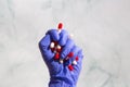 A hand with blue latex gloves grabbing hand full of medicines, Capsules for Vitamines,drugs,medication. Health,business Royalty Free Stock Photo