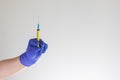 Hand in blue medical glove holding syringe. Medicine, quarantine and COVID-19 coronavirus pandemic concept. Copy space. Royalty Free Stock Photo