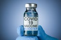 Hand in blue medical gloves holding a vaccine vial with Covid 19 Vaccine Booster text, for Coronavirus booster shot Royalty Free Stock Photo