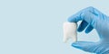 Hand in blue medical gloves holding white molar, dental concept