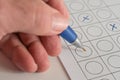 Hand with a blue pen making answer crosses on a paper form, concept for a business application test or voting at an election, copy