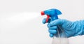 Hand in blue protective glove holding a spray bottle Royalty Free Stock Photo