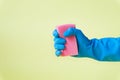 Hand in a blue rubber glove holds red sponge. Royalty Free Stock Photo