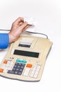 Hand removes check from printing calculator on white background Royalty Free Stock Photo