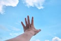 Hand with blue sky and cloud in background. Royalty Free Stock Photo