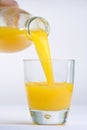 Hand, Bottle pouring Orange juice over glass Royalty Free Stock Photo