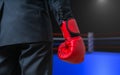 Hand of boxing businessman with red glove in box ring