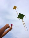 Hand of a boy raises a kite in a sky